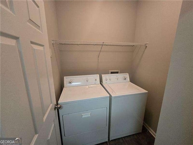 laundry room featuring washer and dryer and dark tile patterned floors