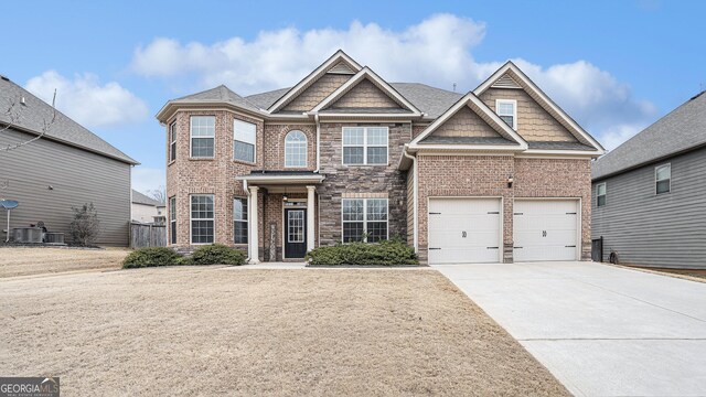 view of front of house with a garage and cooling unit