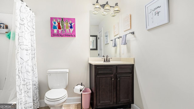 bathroom featuring vanity, toilet, and baseboards