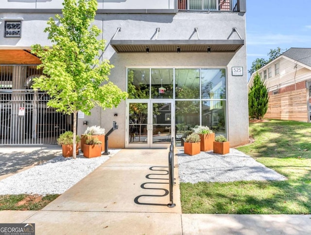 exterior space with stucco siding, french doors, and fence