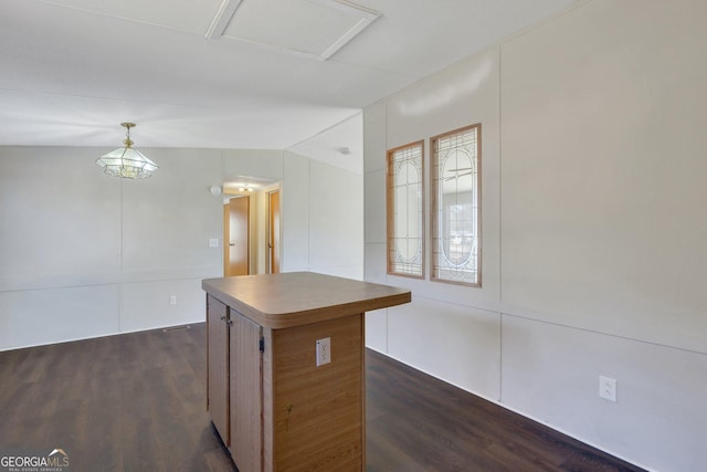 kitchen featuring hanging light fixtures, a center island, dark hardwood / wood-style flooring, and vaulted ceiling