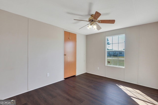 unfurnished room with ceiling fan and dark hardwood / wood-style floors