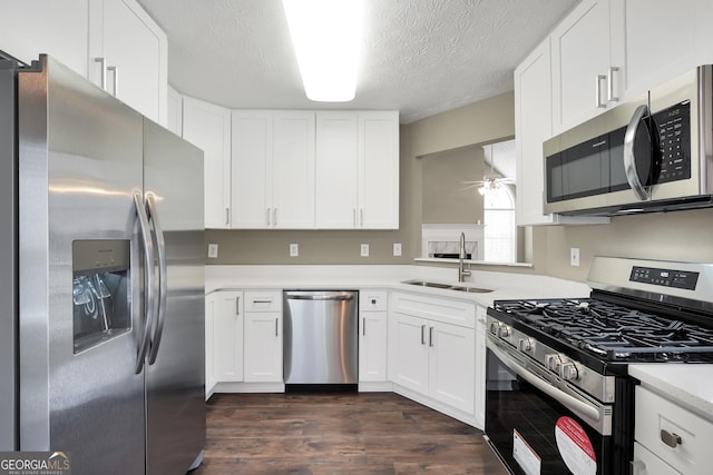 kitchen with sink, white cabinetry, appliances with stainless steel finishes, and dark hardwood / wood-style flooring