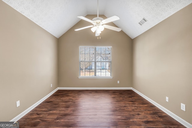 spare room with ceiling fan, vaulted ceiling, dark hardwood / wood-style floors, and a textured ceiling