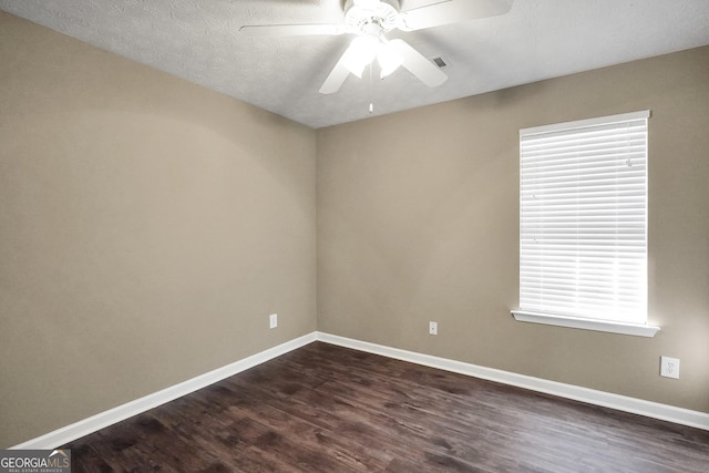 unfurnished room with ceiling fan, dark wood-type flooring, and a textured ceiling