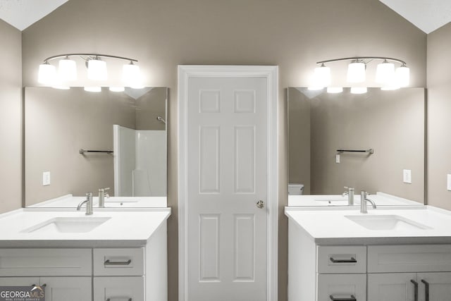 bathroom with a shower, toilet, vanity, and vaulted ceiling