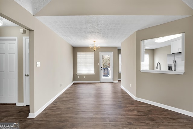 entryway featuring dark hardwood / wood-style floors, sink, an inviting chandelier, and a textured ceiling