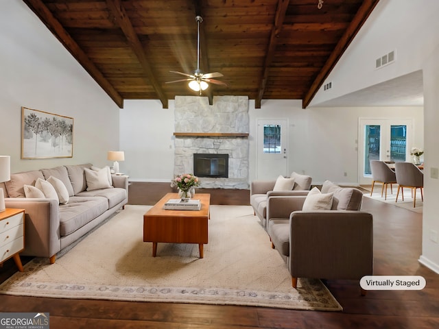 living room featuring wood ceiling, wood-type flooring, lofted ceiling with beams, and a stone fireplace