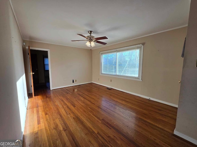 unfurnished room featuring ceiling fan, dark hardwood / wood-style floors, and crown molding