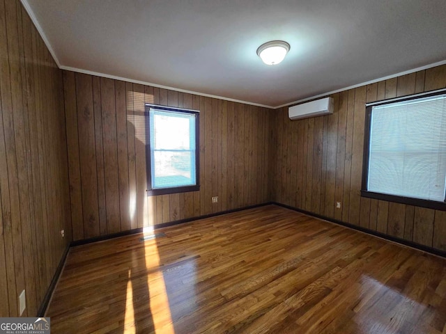 spare room with crown molding, dark hardwood / wood-style flooring, a wall unit AC, and wooden walls