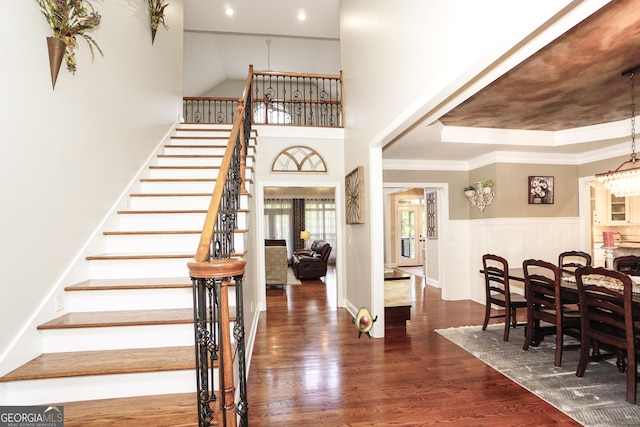 entrance foyer with dark hardwood / wood-style flooring, a tray ceiling, and ornamental molding