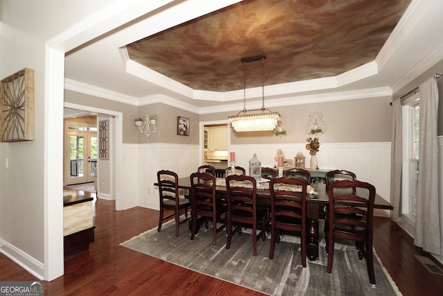 dining room featuring ornamental molding, dark hardwood / wood-style flooring, and a tray ceiling