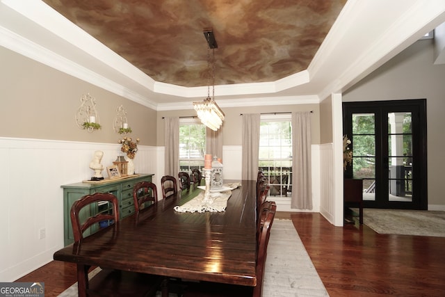 dining area with crown molding, dark hardwood / wood-style flooring, and a raised ceiling