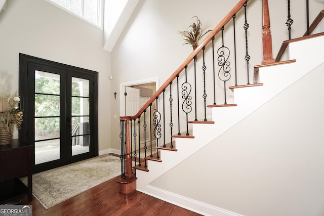 foyer entrance featuring hardwood / wood-style flooring, a high ceiling, and french doors