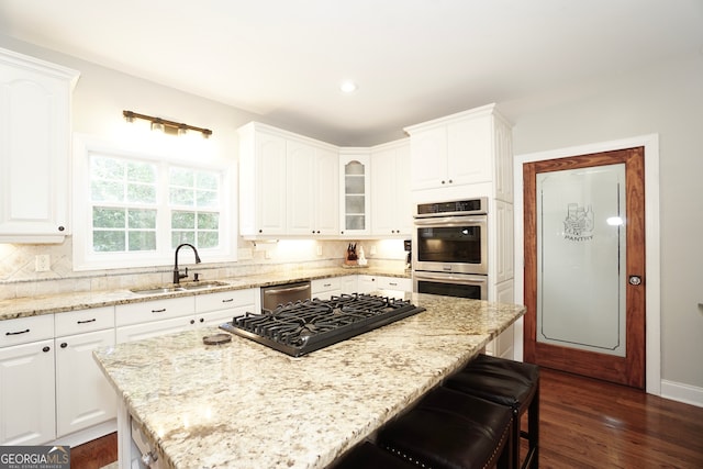 kitchen featuring white cabinets, appliances with stainless steel finishes, sink, and light stone counters