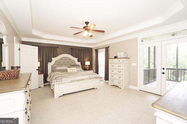 carpeted bedroom featuring ceiling fan, a raised ceiling, access to outside, ornamental molding, and french doors