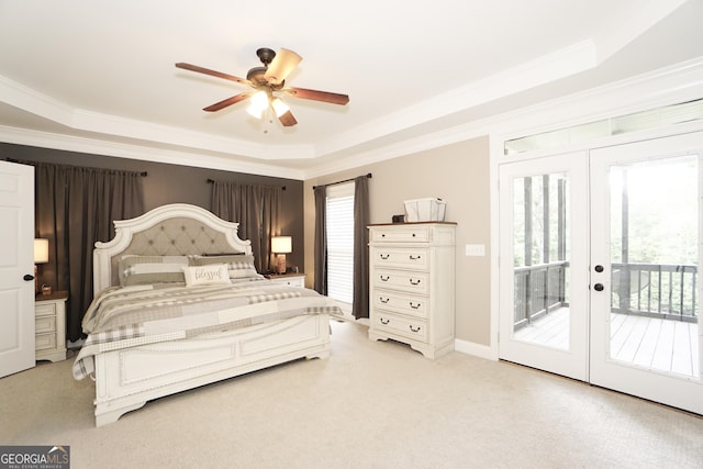 bedroom featuring ceiling fan, light colored carpet, a tray ceiling, and access to outside