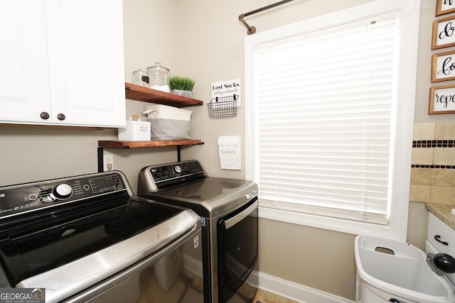 washroom with cabinets and washing machine and clothes dryer