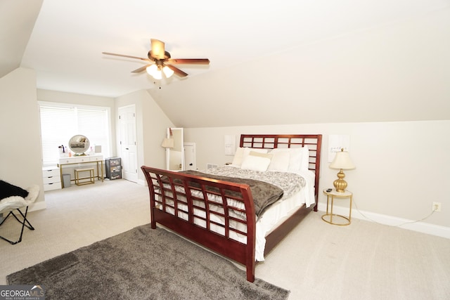 bedroom with ceiling fan, lofted ceiling, and light colored carpet