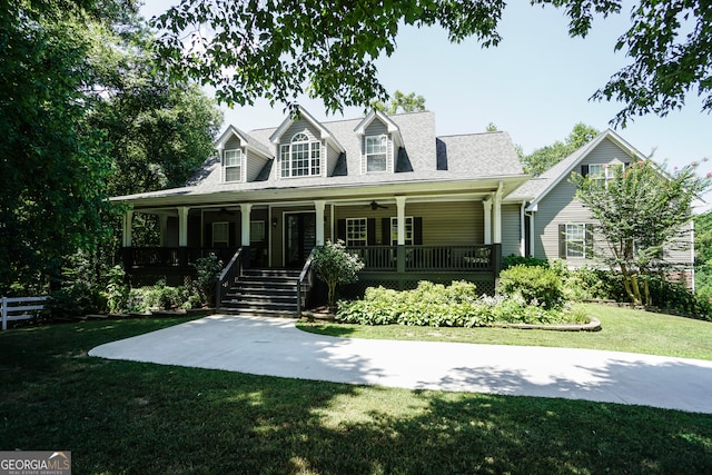 new england style home with covered porch, ceiling fan, and a front lawn