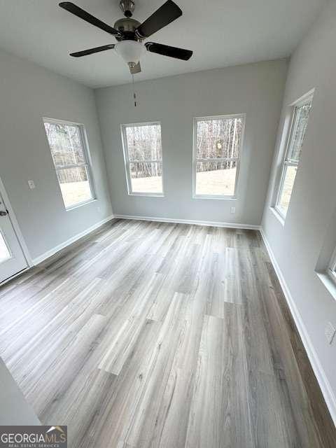 unfurnished room featuring light wood-type flooring and ceiling fan