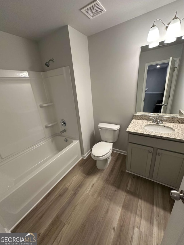 full bathroom with wood-type flooring, shower / bath combination, toilet, and vanity