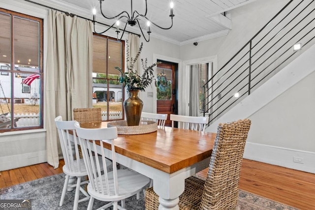 dining space featuring hardwood / wood-style floors, crown molding, and a notable chandelier