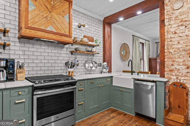 kitchen with sink, green cabinetry, appliances with stainless steel finishes, dark hardwood / wood-style flooring, and decorative backsplash