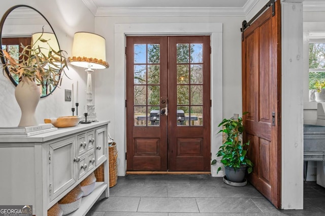 doorway to outside with light tile patterned flooring, ornamental molding, a barn door, and french doors