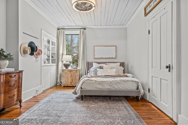 bedroom featuring hardwood / wood-style floors, wood ceiling, and ornamental molding