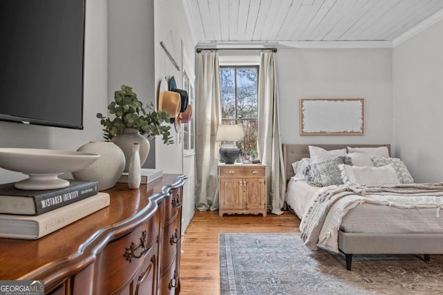 bedroom with ornamental molding, wood ceiling, and light hardwood / wood-style floors