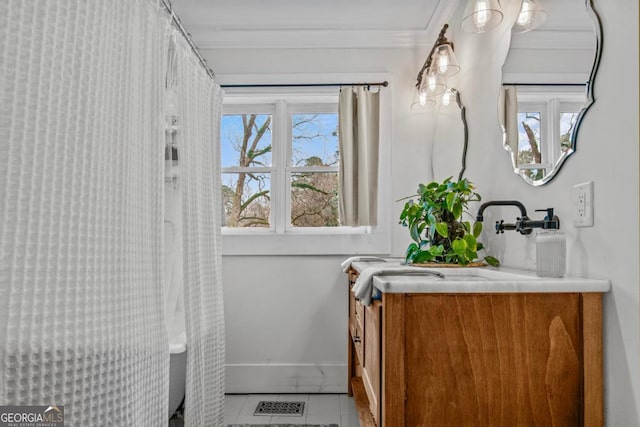 bathroom with tile patterned flooring, ornamental molding, and sink