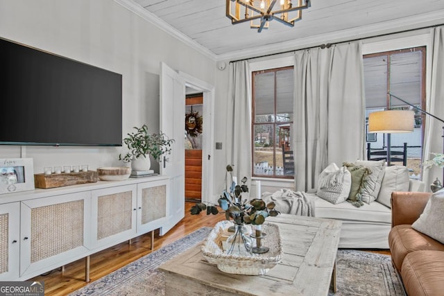 living room with hardwood / wood-style floors, crown molding, and a notable chandelier