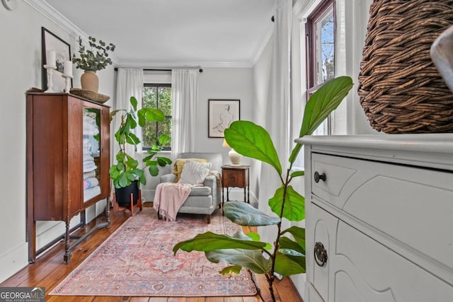 living area with ornamental molding and light hardwood / wood-style floors