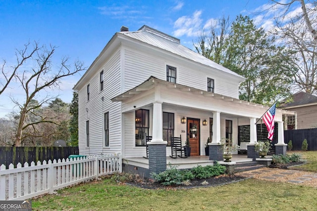 view of front of house with a front yard and covered porch