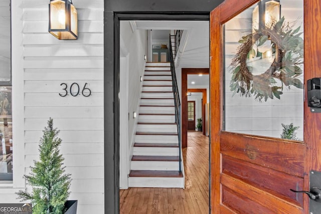 stairway featuring hardwood / wood-style floors and wooden walls