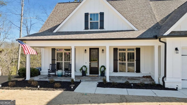 view of front of house with a porch, board and batten siding, and roof with shingles