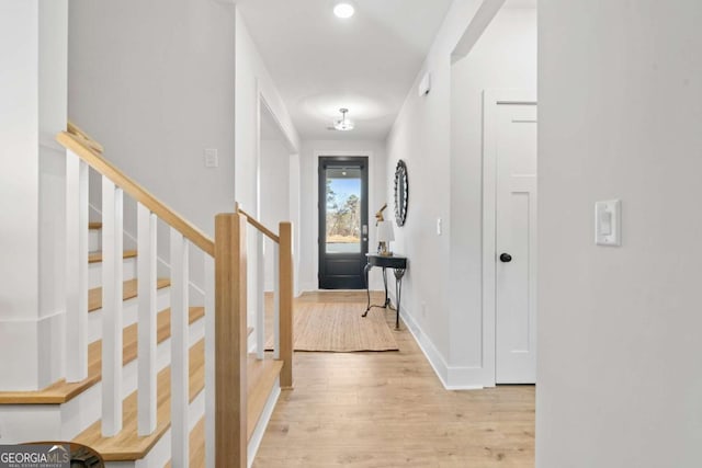 entrance foyer with stairway, baseboards, and light wood-style flooring