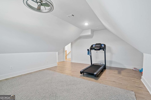 exercise room with visible vents, baseboards, lofted ceiling, and wood finished floors