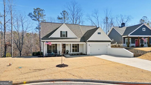 view of front of property featuring an attached garage, a porch, driveway, and a shingled roof