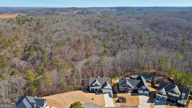 birds eye view of property featuring a view of trees