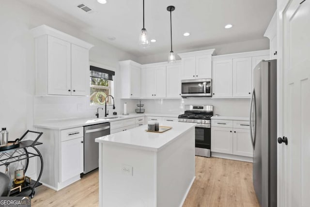 kitchen featuring visible vents, white cabinets, appliances with stainless steel finishes, and a sink