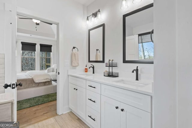 ensuite bathroom featuring double vanity, wood finished floors, ensuite bathroom, and a sink