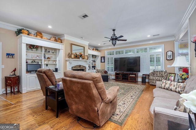 living room featuring ceiling fan, ornamental molding, and light hardwood / wood-style flooring