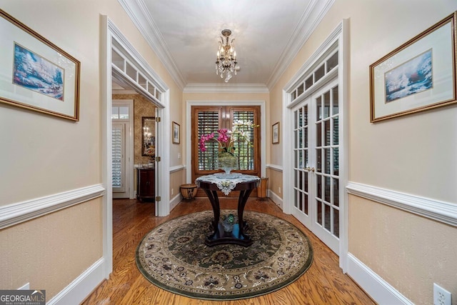 interior space featuring french doors, a notable chandelier, ornamental molding, and hardwood / wood-style floors