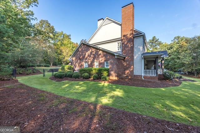 view of side of property featuring a lawn and a porch