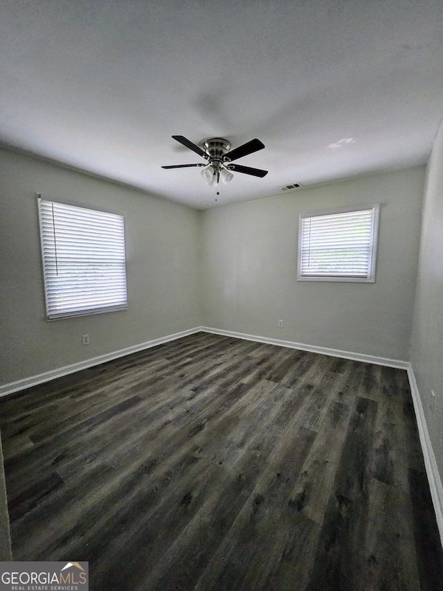 unfurnished room with ceiling fan and dark hardwood / wood-style flooring