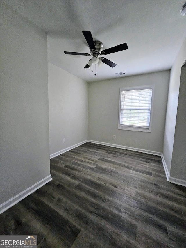 empty room with ceiling fan and dark hardwood / wood-style flooring