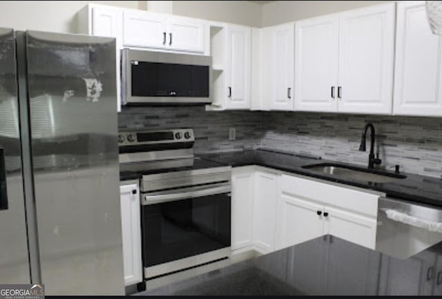 kitchen featuring stainless steel appliances, white cabinetry, and sink