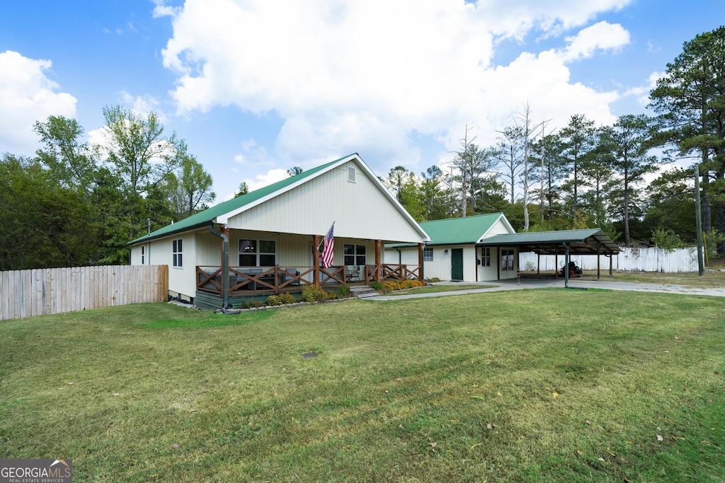 view of front facade with covered porch, a front lawn, and a carport